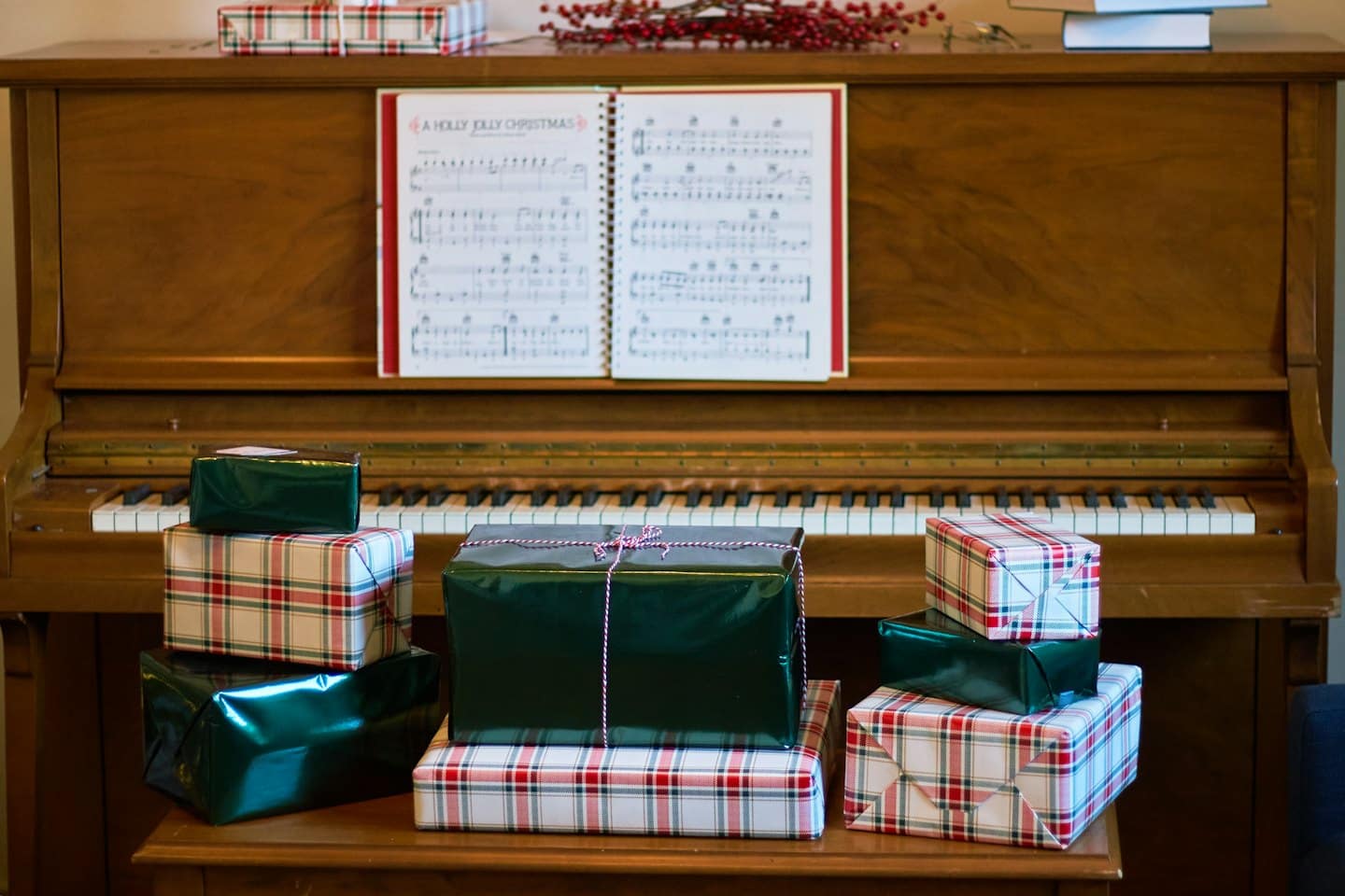 Piano decorated with Christmas presents and sheet music.