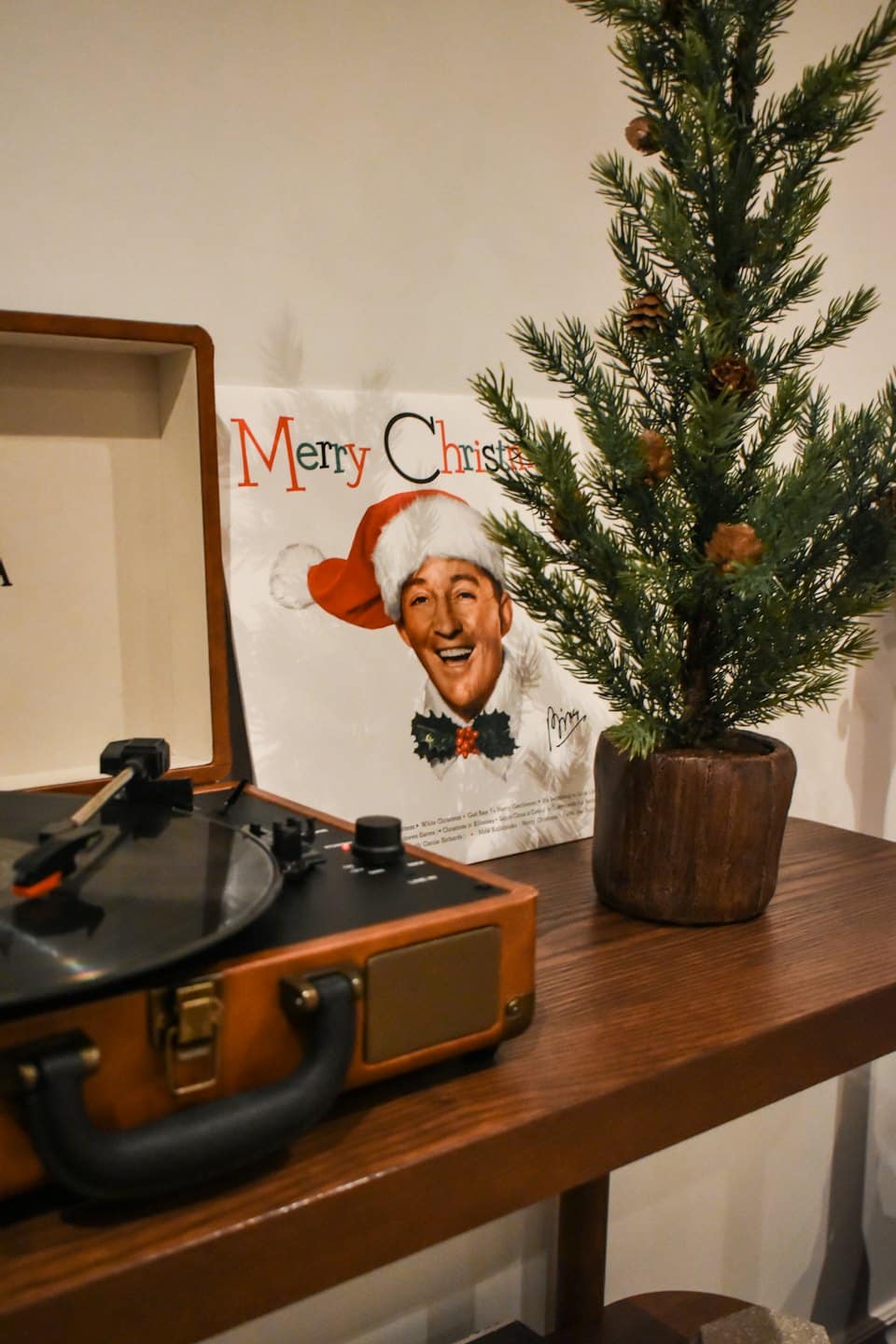 A vintage record player and Christmas decor on a shelf.