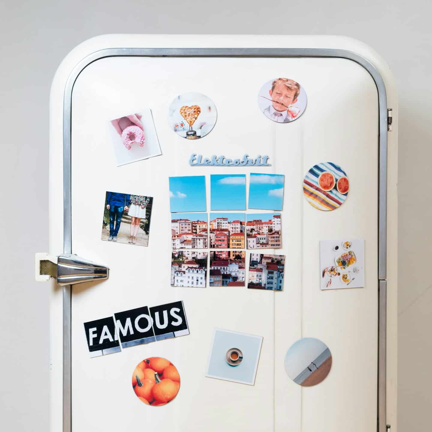 Cream refrigerator door covered in magnets and photos.