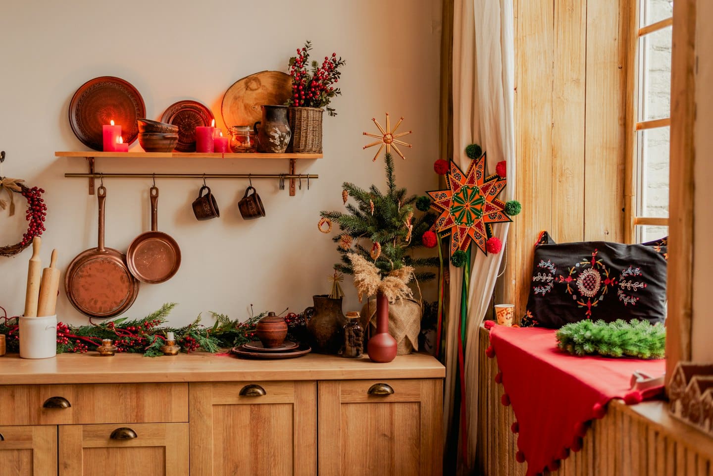 Festive kitchen with Christmas tree and glowing candles.